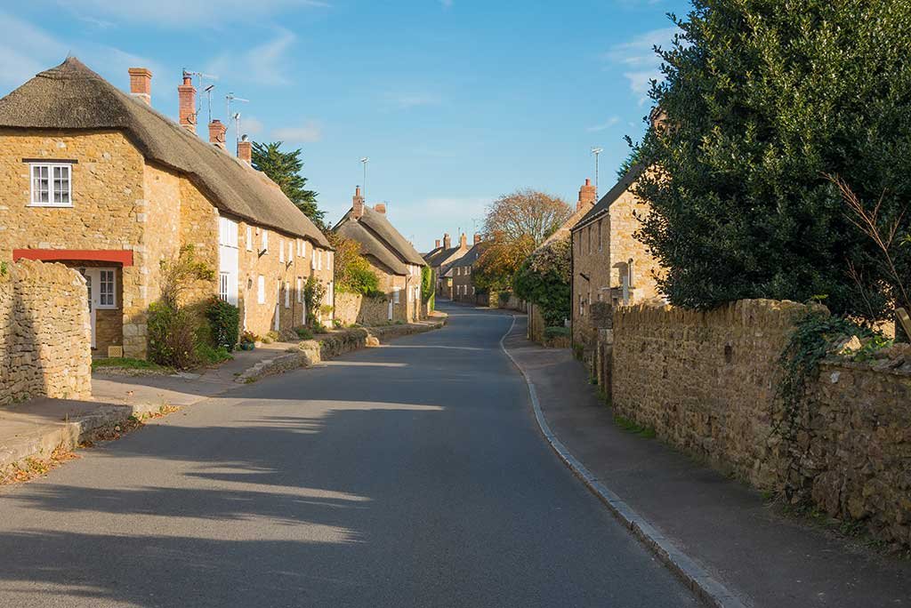 Abbotsbury village street showing thatched cottages
