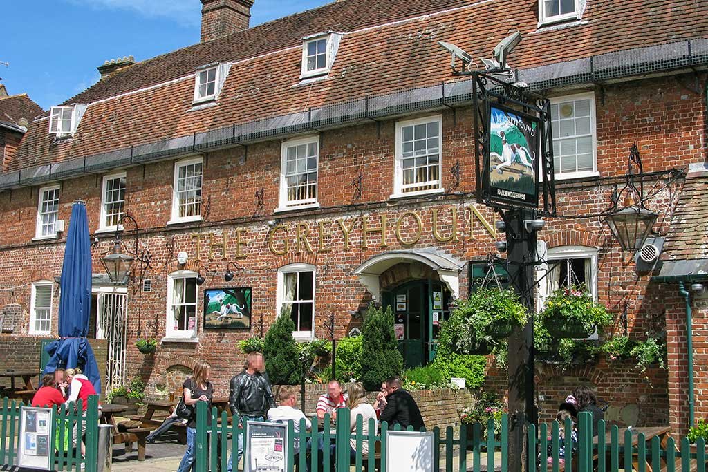 View of the Greyhound Pub in Blandford with outdoor seating area