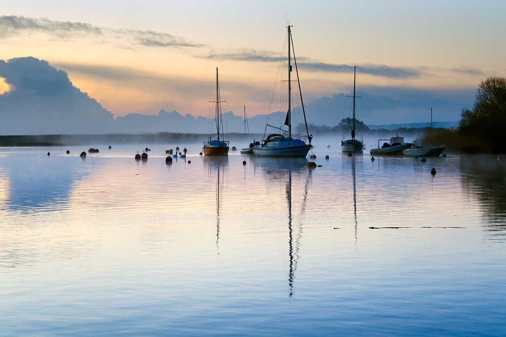 Boats early in the morning on the River Stour by Christchurch Quay